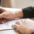 Cropped View of Woman Filling in Application Form